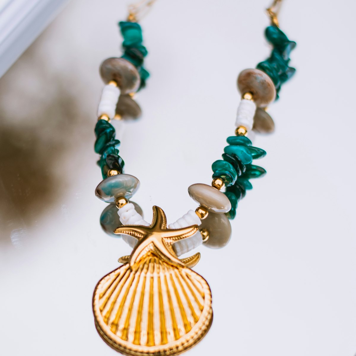 Detalhe do colar de turquesas com pingente dourado