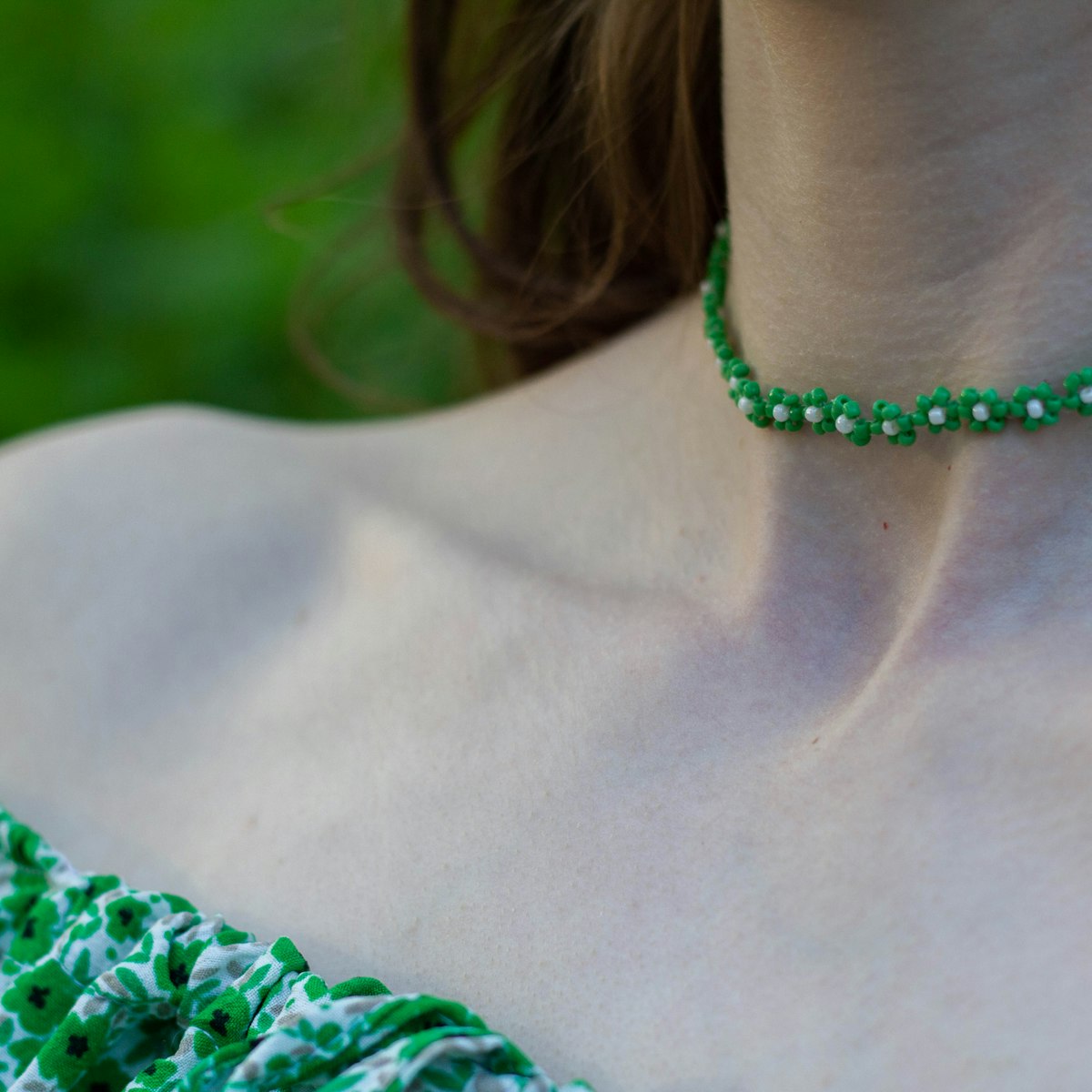 Mulher usando gargantilha de contas verdes