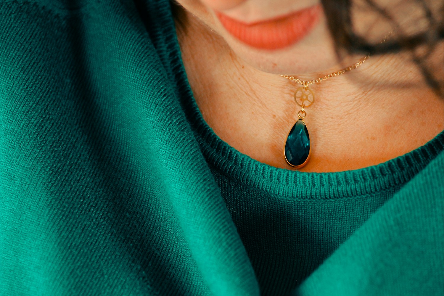 Colar com pedra verde sobre roupa verde-esmeralda